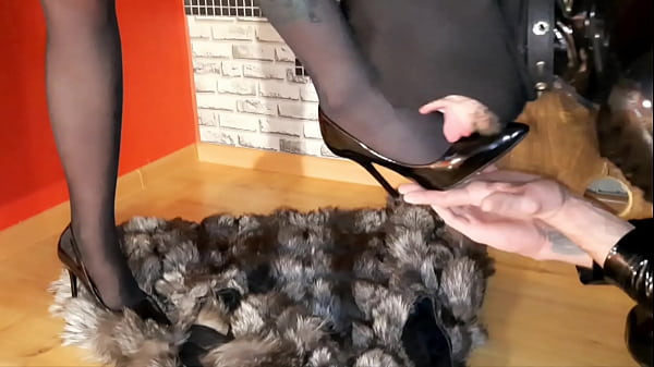 The slave worships the legs in pointed shoes. Shoes fetish. The slave kisses and licks the shoes.