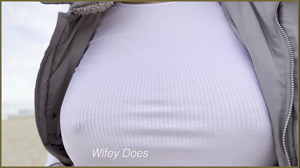 Frau ohne BH geht am öffentlichen Strand spazieren